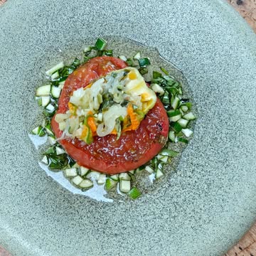 L'été arrive.

Fleur de courgette farcie a l'oignon jeune et courgette, tomate laquée au caramel de fraise, eau de tomate a l'estragon.

Bon nous sommes encore sur un plat a simplifier, ou plutôt a épurer, mais j'aime l'énergie des différents éléments. Déjà, on sent que la saison de la tomate arrive, que celle de la courgette est bien présente, puis la tomate passée au feu de bois est toujours fondante, mais il manque la clarté du message.

Entre l'estragon du jus et la sarriette de la farce de fleur, l'été se voudra olfactif chez Magneus!