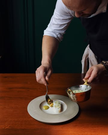 Le lieu jaune poché dans un bouillon de feuilles de citronnier, il est accompagné de moules de bouchot dans leur jus monté au beurre et de haricots beurre.

Un condiment de yuzu confit et piment Padrón, citron caviar et yuzu frais viennent terminer l’assiette.

-

Pollock poached in a lemon leaf broth, served with bouchot mussels in their own jus finished with butter, and yellow wax beans.

A condiment of preserved yuzu and Padrón pepper, finger lime and fresh yuzu complete the dish.

📷 @maurine.toussaint