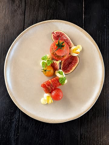 Tomates & figues du jardin.

Une déclinaison autour de deux fruits de saison, travaillés dans leur entièreté pour en concentrer les goûts.

Le sorbet associe l’intérieur des tomates, qui apporte naturellement l’acidité, à la feuille de figuier pour sa fraîcheur végétale. Plus qu’un élément sucré, il est pensé comme un condiment.

Tomates et figues sont aussi confites puis compressées pour apporter de la texture, et servies presque brutes, simplement assaisonnées de feuille de figuier déshydratée et de cardamome verte.